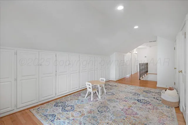 an empty room with wooden floor and ceiling fan