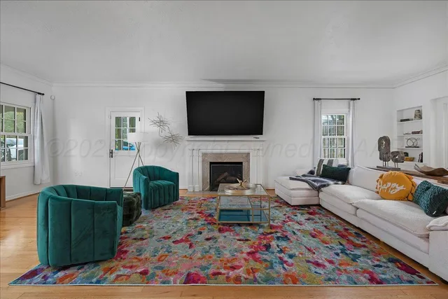 a living room with furniture a flat screen tv and a fireplace