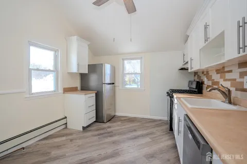 a kitchen with granite countertop a sink stove and refrigerator