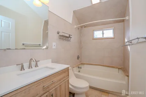 a bathroom with a granite countertop sink toilet and bathtub