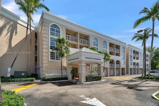 a view of a building with a yard and palm trees
