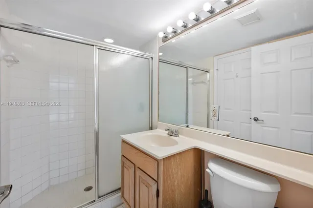 a view of an empty room with wooden floor and a living room