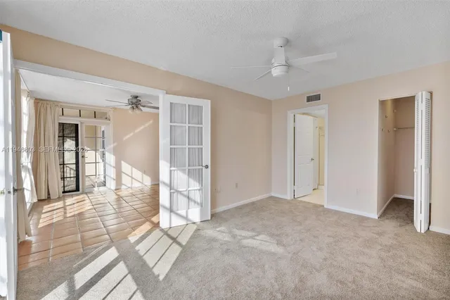an empty room with closet and a chandelier fan