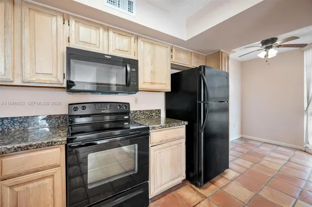 a kitchen with stainless steel appliances granite countertop a stove top oven microwave and cabinets