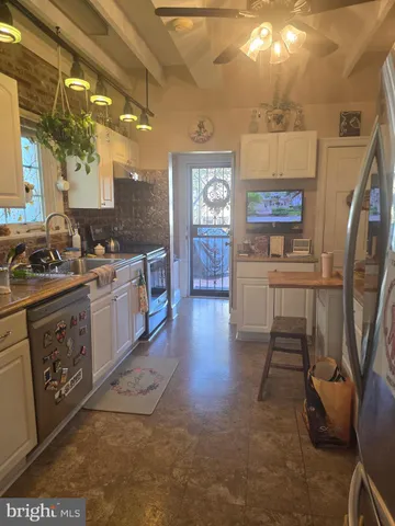 a kitchen with stainless steel appliances granite countertop a refrigerator and a stove