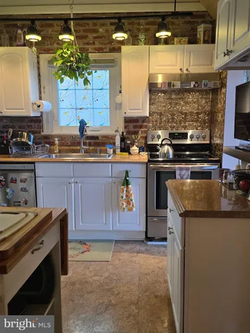 a kitchen with granite countertop a sink a stove and cabinets