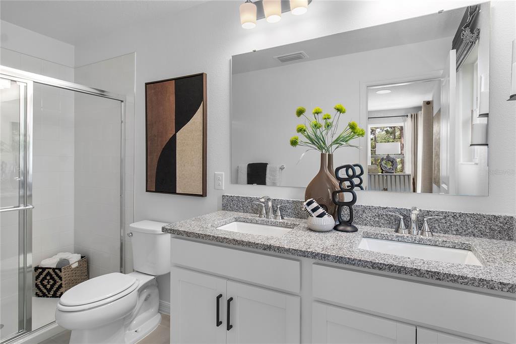 16639 Luminary Loop Clermont, FL 34714 - Photo 21 of 26 a bathroom with a granite countertop sink a toilet and a mirror