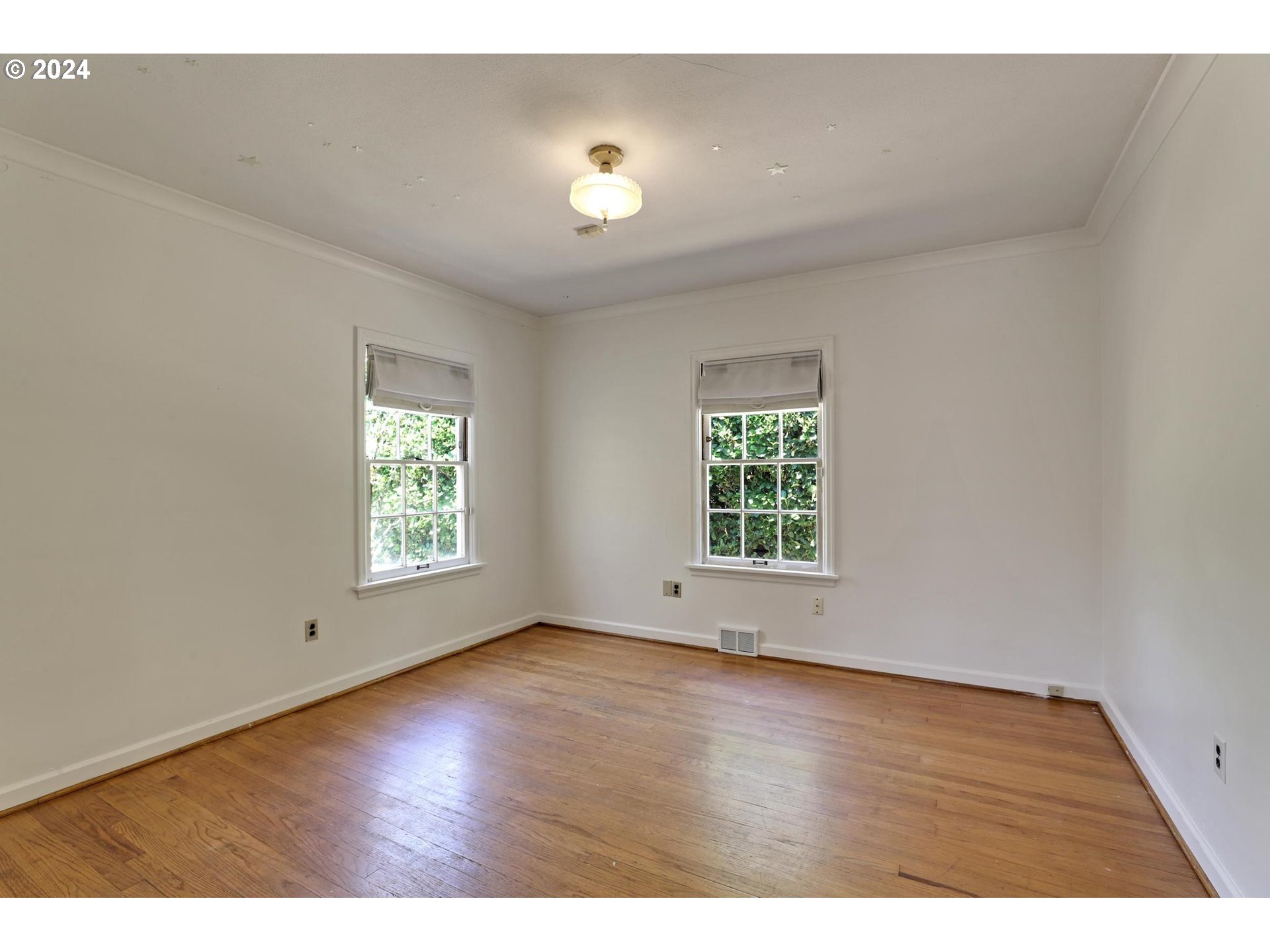 6003 Southeast Stephens Street Portland, OR 97215 - Photo 23 of 46 a view of an empty room with wooden floor and a window