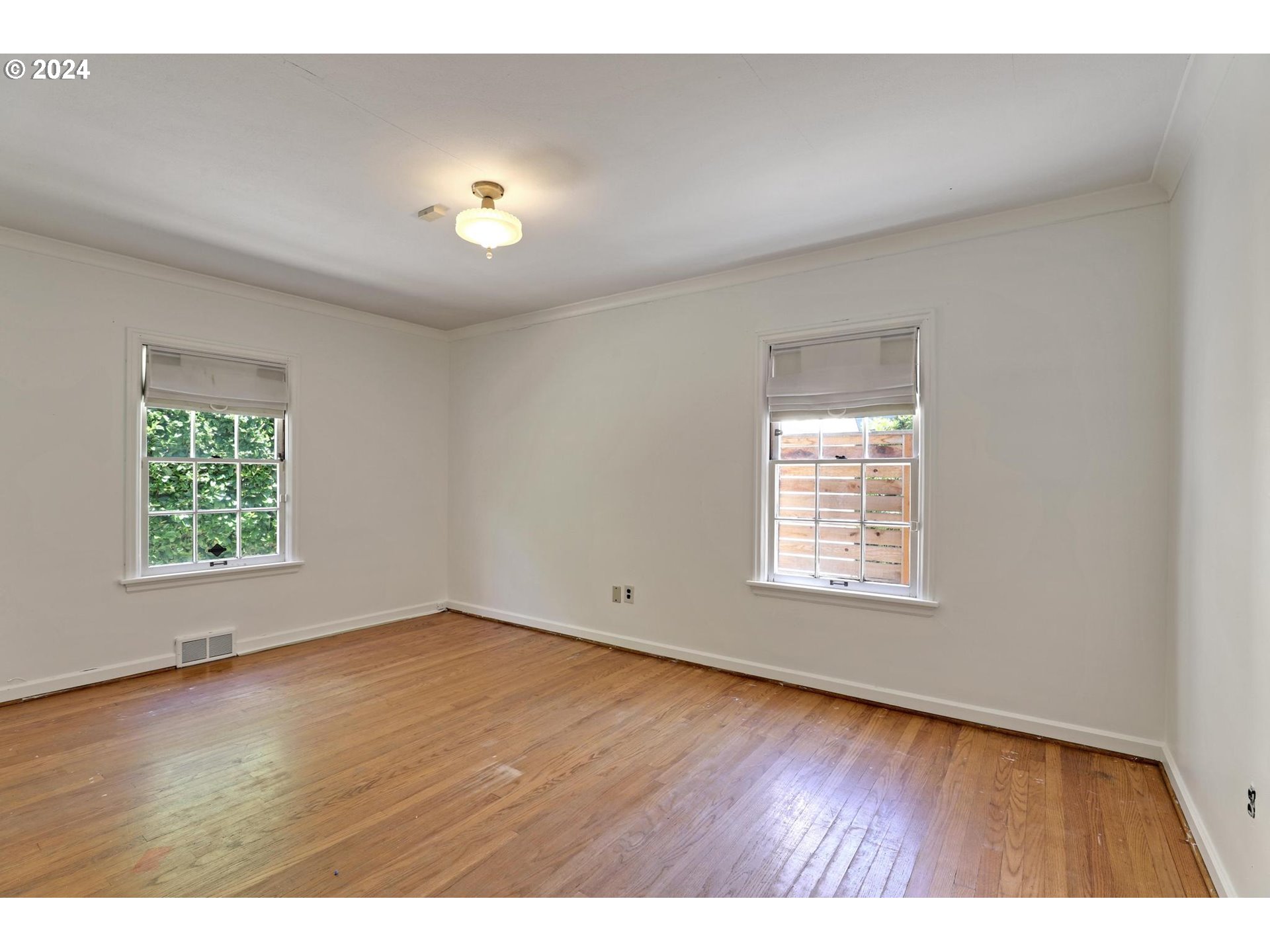 6003 Southeast Stephens Street Portland, OR 97215 - Photo 24 of 46 an empty room with wooden floor and windows