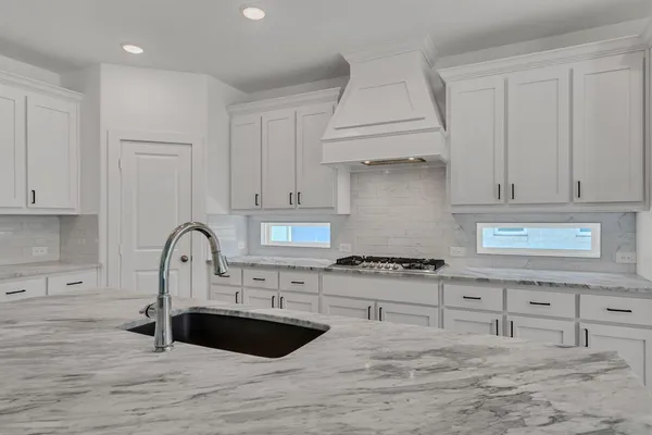 a kitchen with granite countertop a stove a sink and a granite counter tops