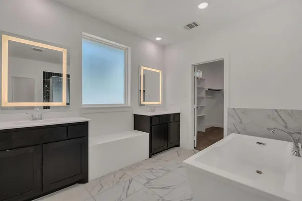 a bathroom with a tub sink and mirror