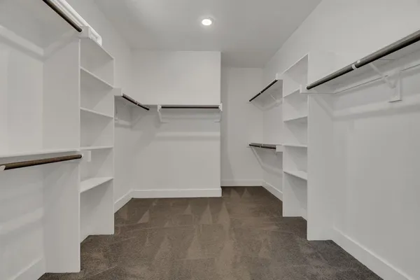 a view of walk in closet with empty racks