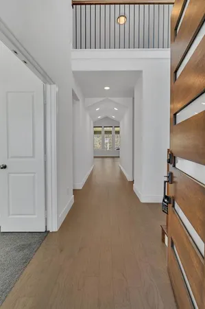 a view of a hallway with wooden floor and staircase