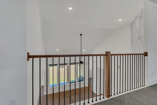 a bed sitting in a bedroom next to a window and a table