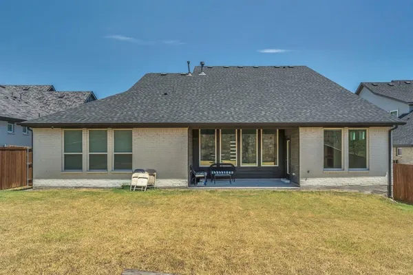 a view of a house with backyard and sitting area