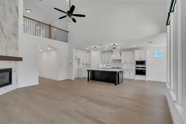 a view of kitchen with kitchen island wooden floor center island and stainless steel appliances