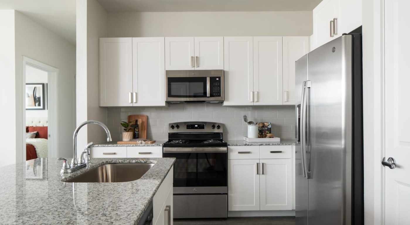 12111 South Main Street, Unit 13306 Houston, TX 77035 - Photo 11 of 24 a kitchen with white cabinets sink and stainless steel appliances
