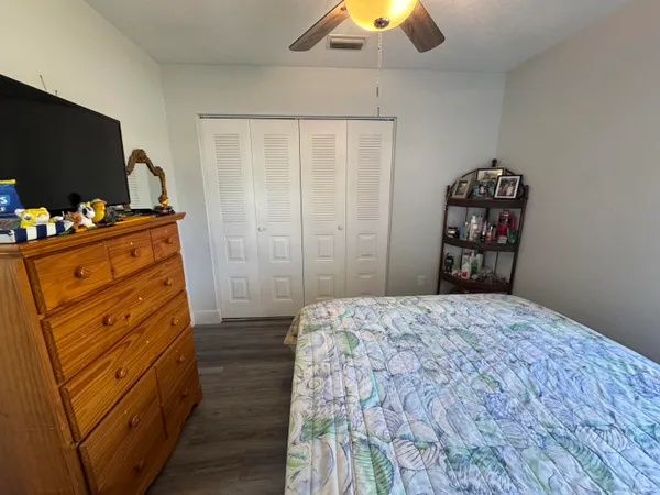 a bedroom with a bed and a flat tv screen on dresser