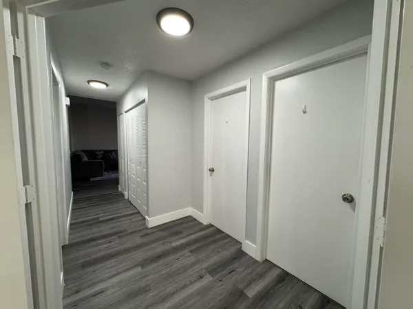 a view of a hallway with wooden floor and closet