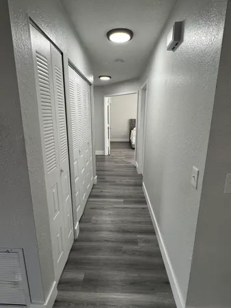 a view of a hallway with wooden floor and staircase