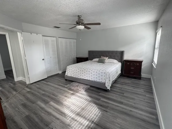 a bedroom with a bed and wooden floor