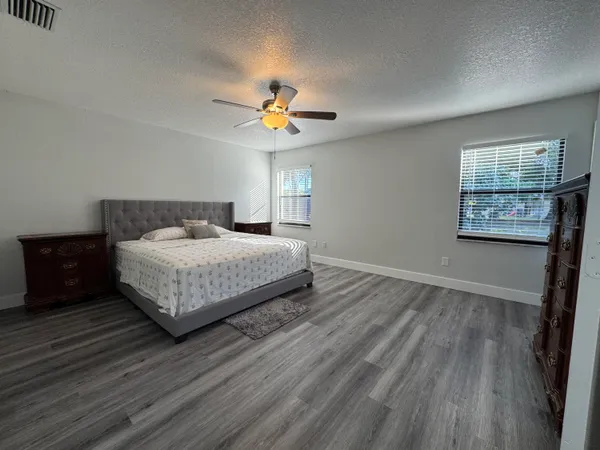 a bedroom with a bed a chandelier and a window