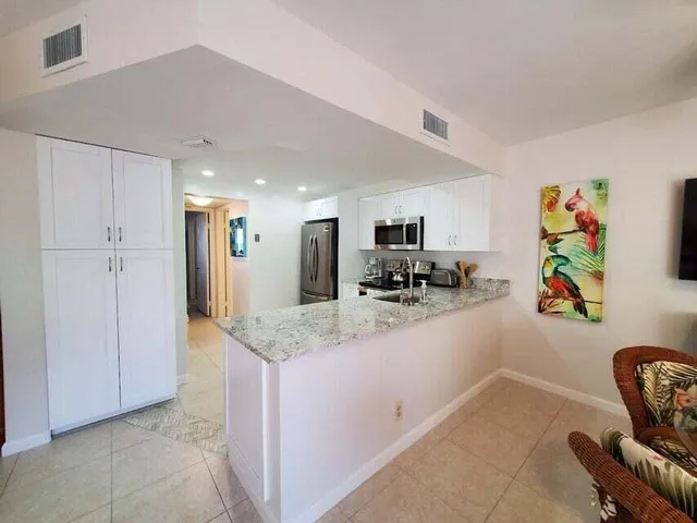 a kitchen with granite countertop appliances cabinets and a sink