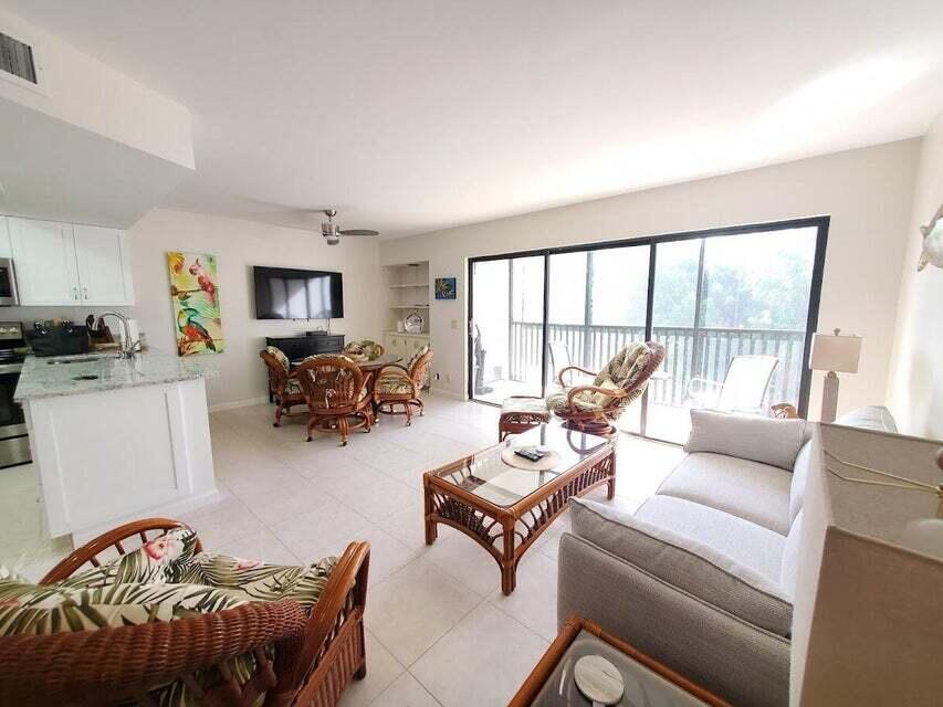 1605 Highway 1, Unit F203 Jupiter, FL 33477 - Photo 10 of 39 a living room with furniture large window and a table