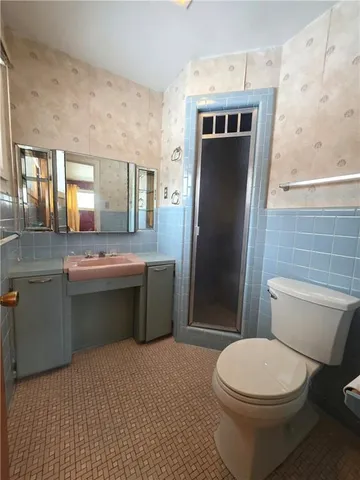 a bathroom with a toilet sink and mirror