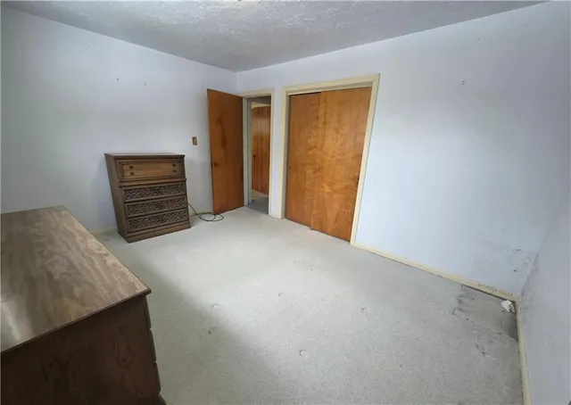 a view of an empty room with furniture and a window