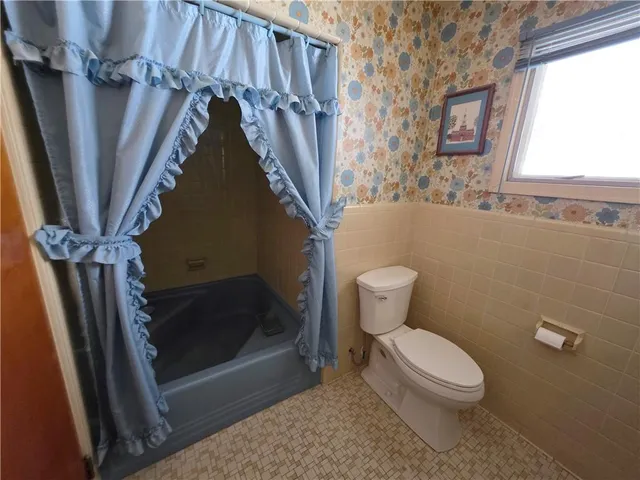 a bathroom with a toilet and a shower