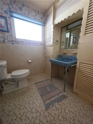 a bathroom with a sink a toilet and a window