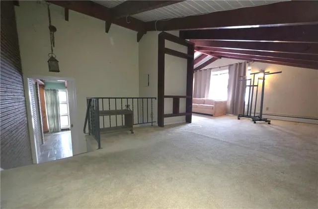 a view of a hallway with furniture and a window