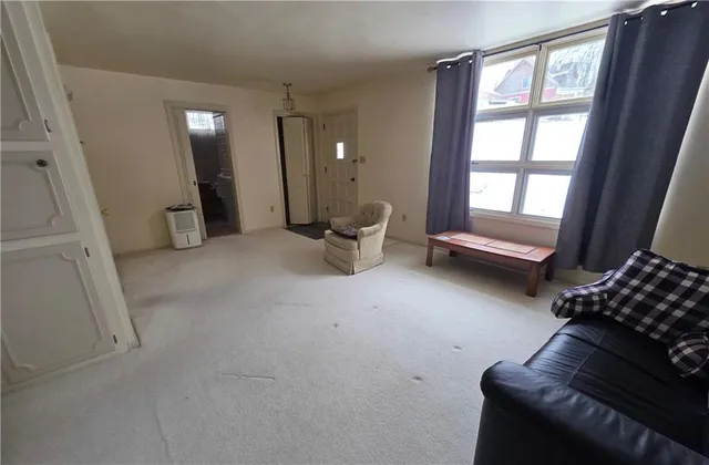 a view of an empty room with furniture and windows