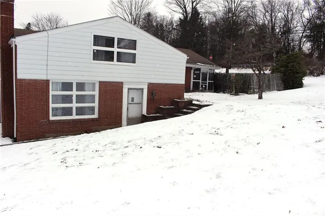 a view of a house with a yard covered in snow