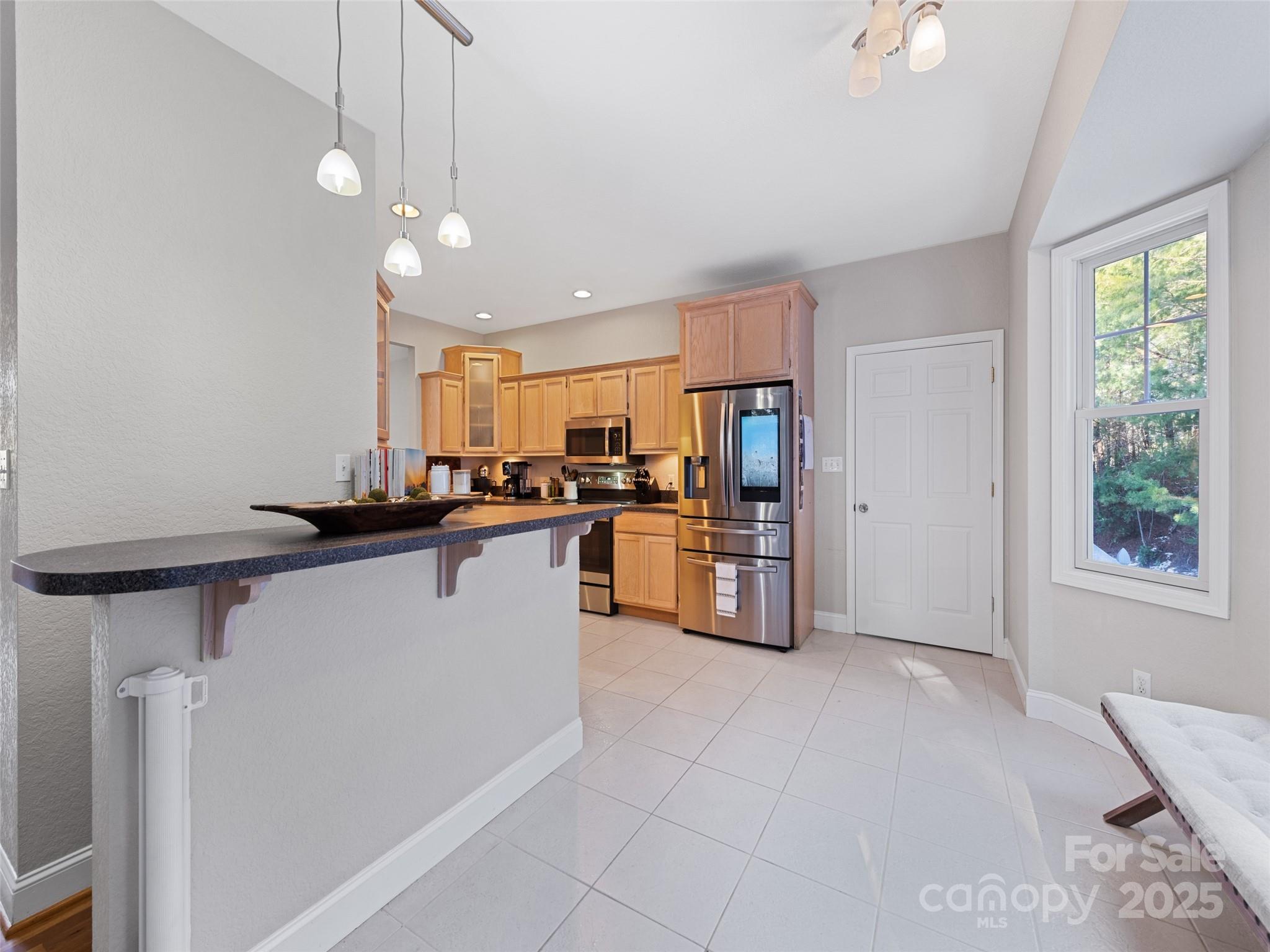 15 Lone Coyote Ridge Fletcher, NC 28732 - Photo 28 of 46 a kitchen with stainless steel appliances a refrigerator a stove a sink dishwasher and microwave with wooden floor