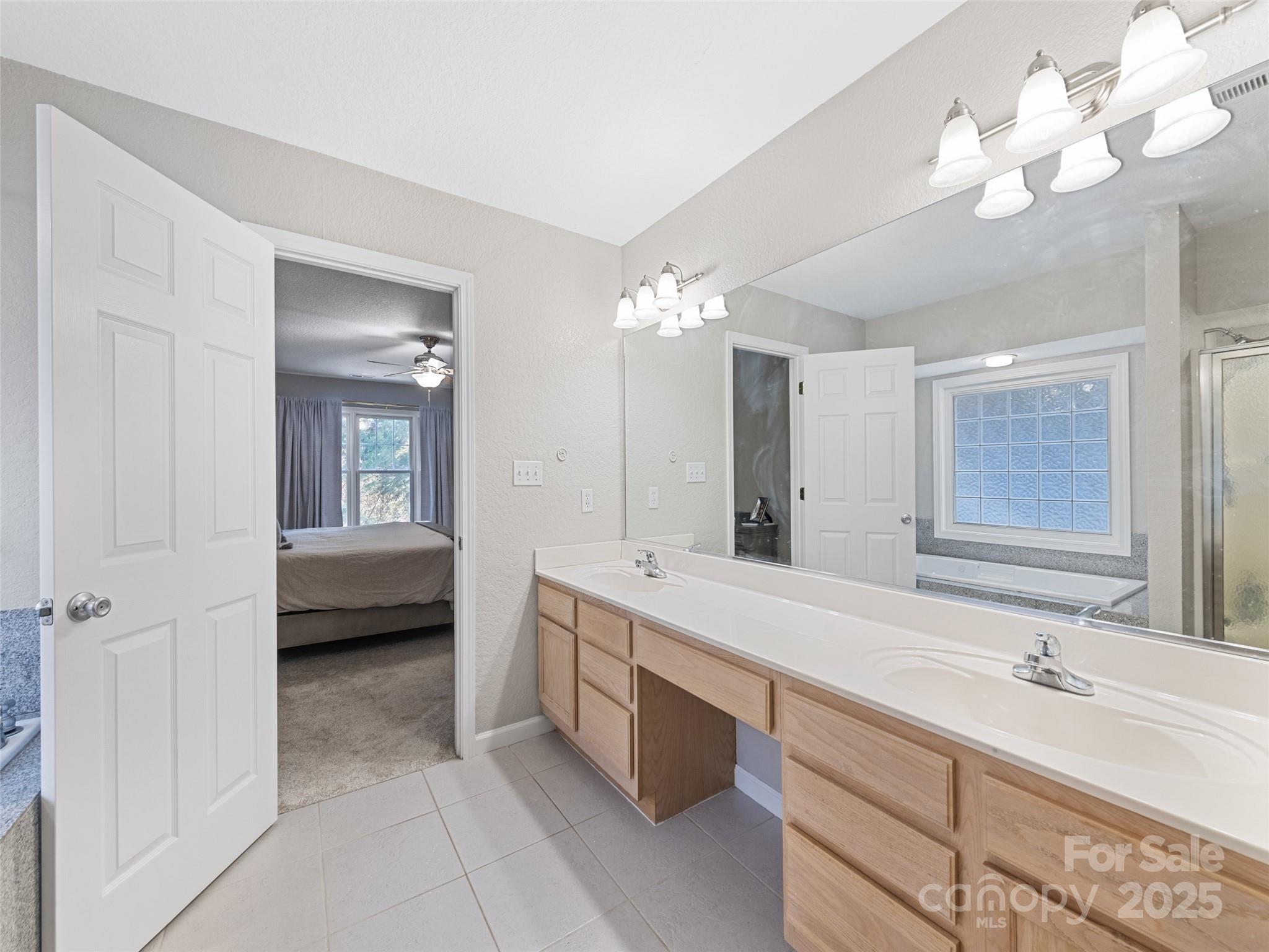 15 Lone Coyote Ridge Fletcher, NC 28732 - Photo 38 of 46 a spacious bathroom with a double vanity sink a large mirror and a bathtub