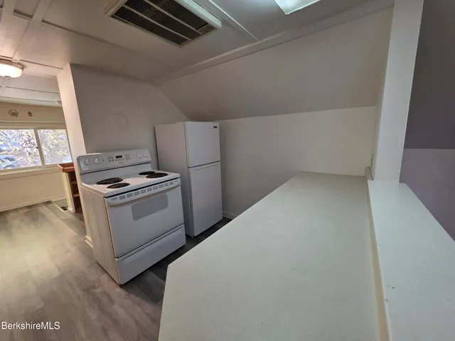 a kitchen with white cabinets and white appliances