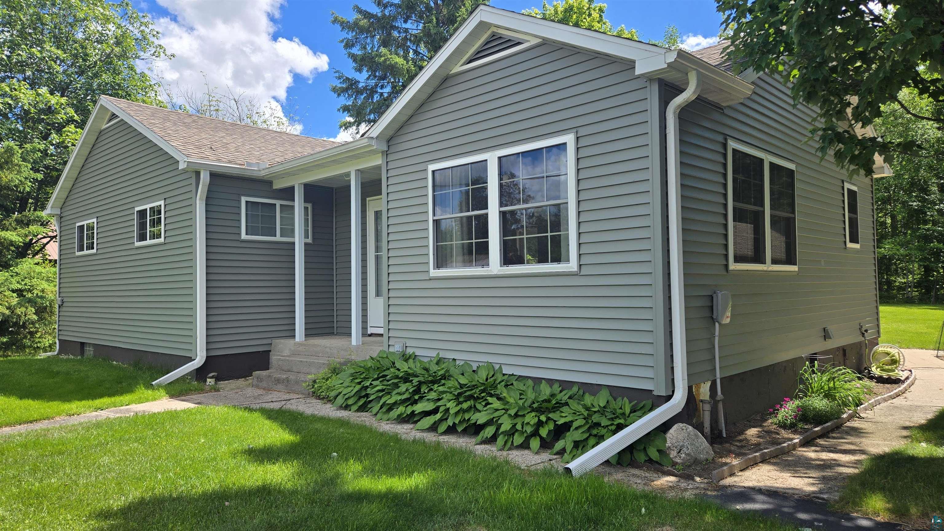 10614 Moose Lake Road Orr, MN 55771 - Photo 2 of 44 Exterior facade featuring horizontal siding, white trim windows, and a covered entry porch