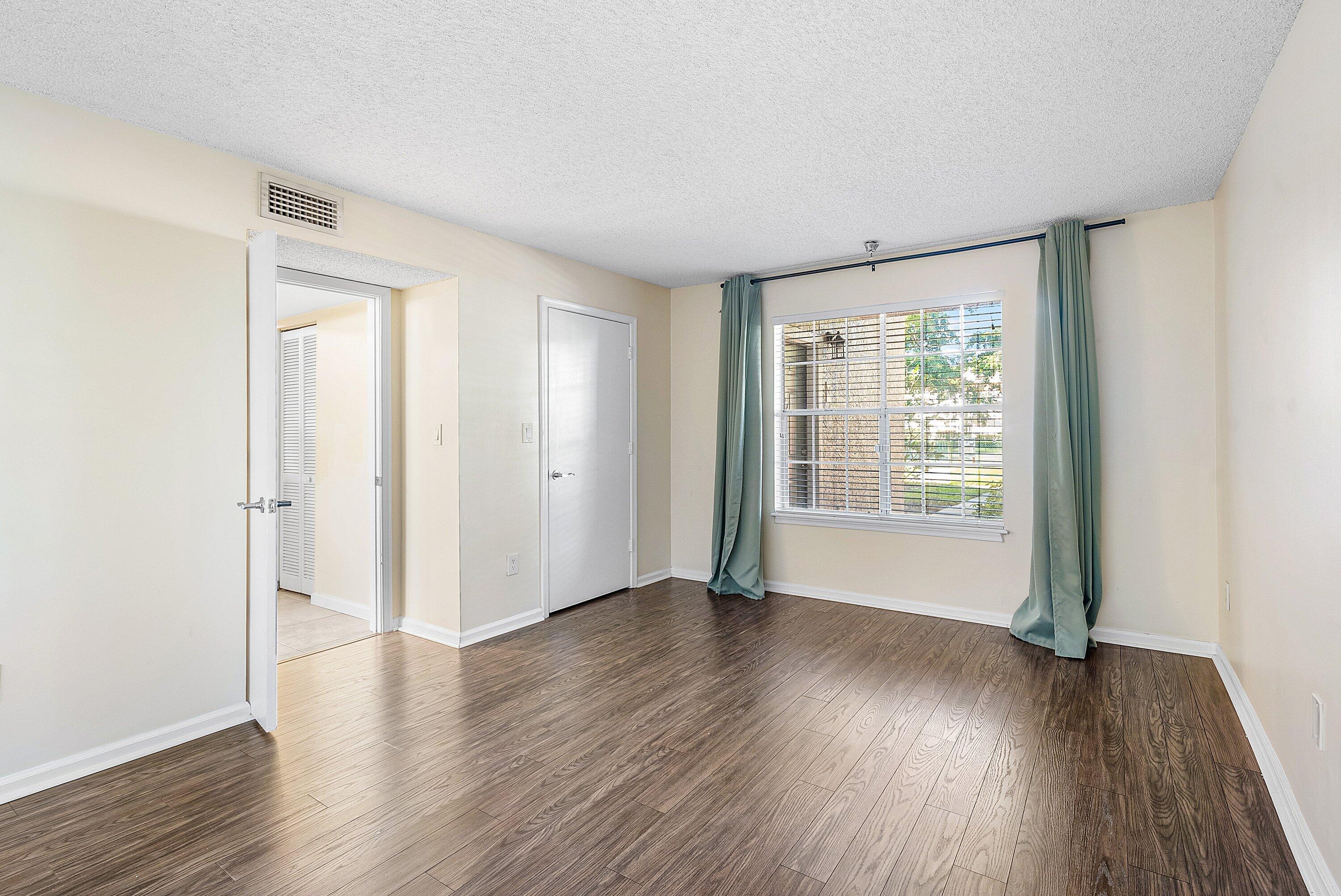 1001 Crystal Way, Unit M Delray Beach, FL 33444 - Photo 18 of 42 a view of an empty room with wooden floor and a window