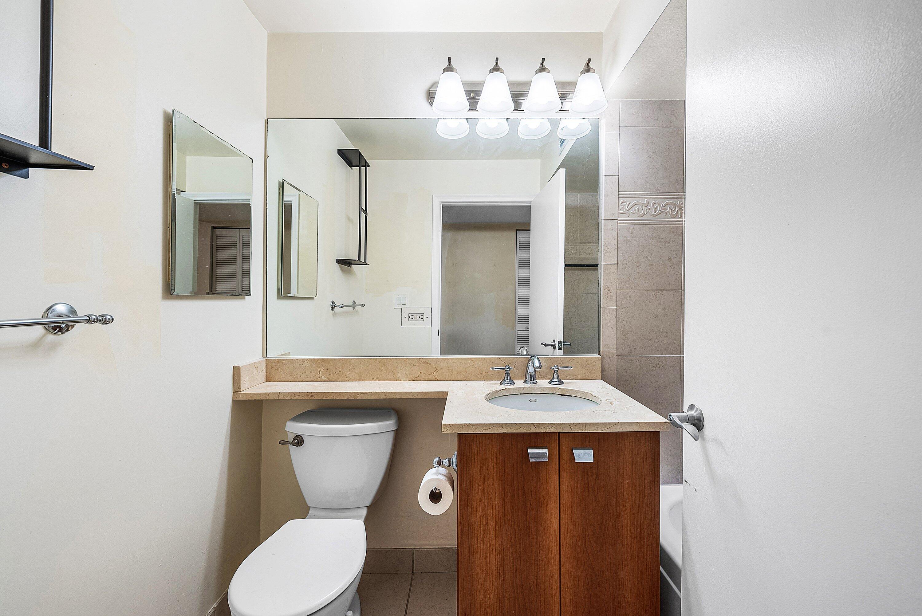 1001 Crystal Way, Unit M Delray Beach, FL 33444 - Photo 20 of 42 a bathroom with a toilet a sink and mirror