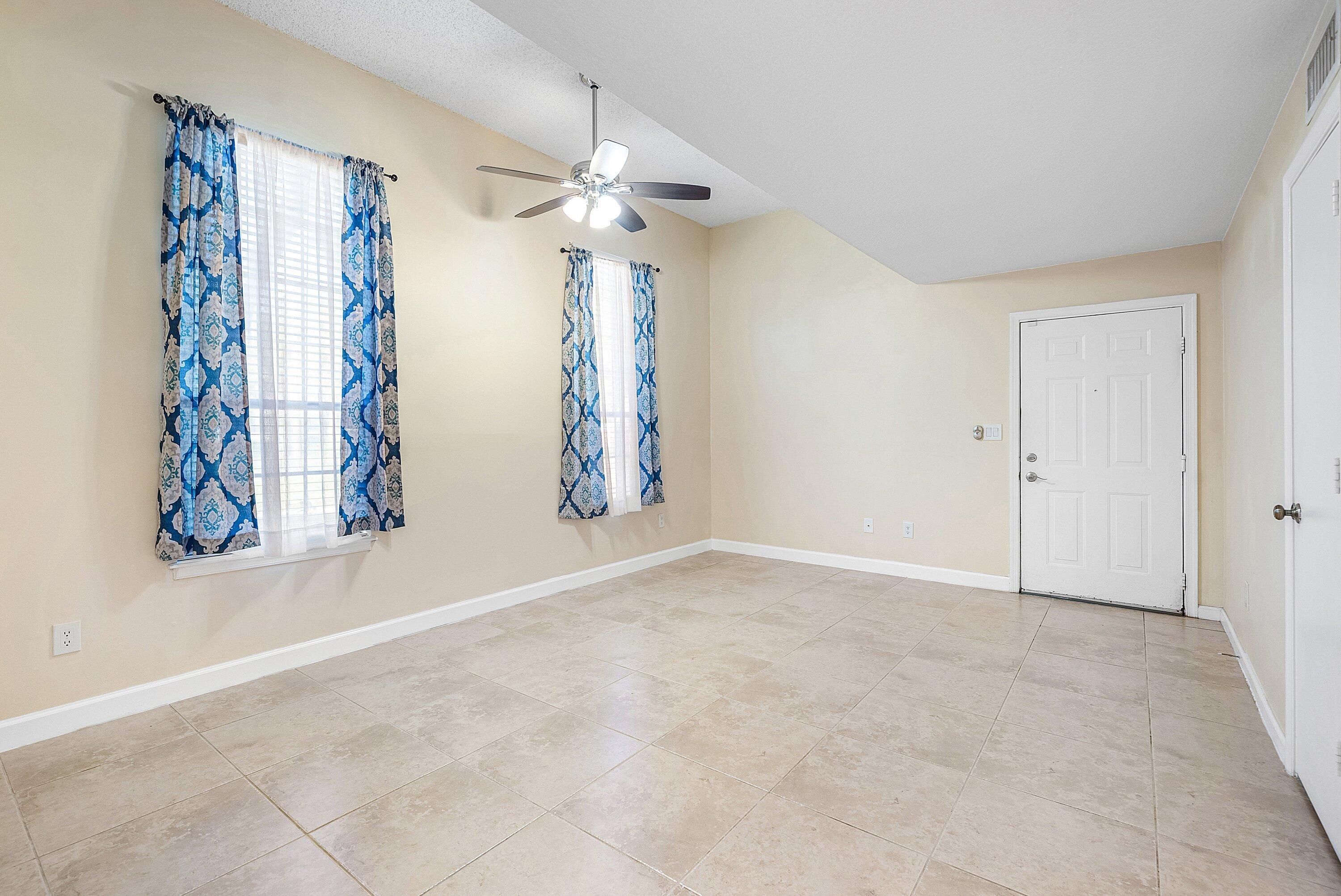 1001 Crystal Way, Unit M Delray Beach, FL 33444 - Photo 6 of 42 an empty room with windows and chandelier fan