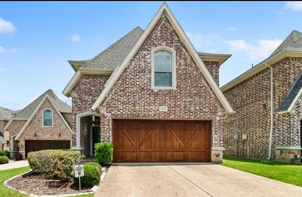 a front view of a house with a garden and plants