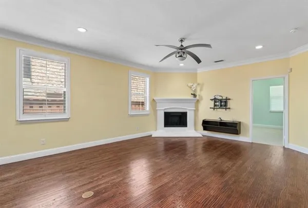 a view of a livingroom with wooden floor fireplace and stairs
