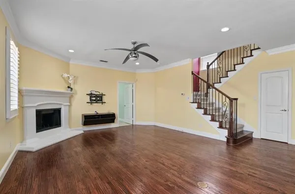 a view of a livingroom with wooden floor and stairs