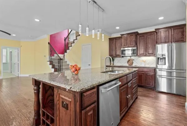 a kitchen with stainless steel appliances granite countertop a table and chairs