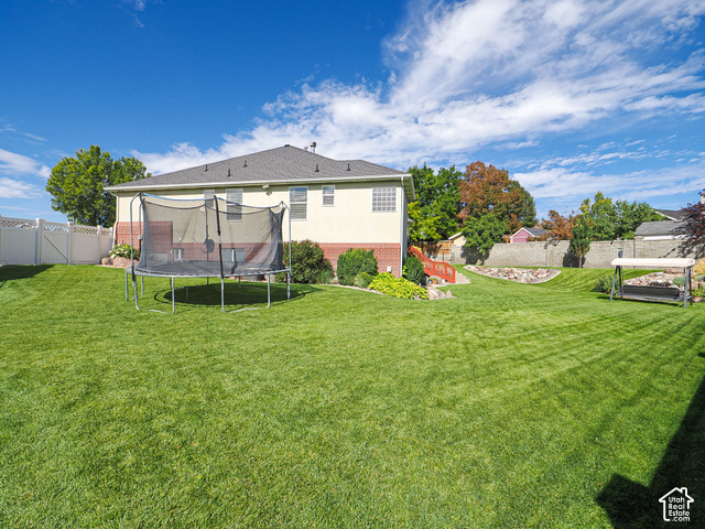 11779 South Stone Ridge Court Ridge West Riverton, UT 84065 - Photo 73 of 85 Expansive backyard featuring a manicured lawn, established landscaping, and a tiered design with retaining walls