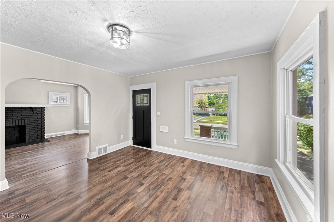 2195 Barrington Road Cleveland, OH 44118 - Photo 12 of 50 Unfurnished living room with a textured ceiling, a brick fireplace, and hardwood / wood-style floors