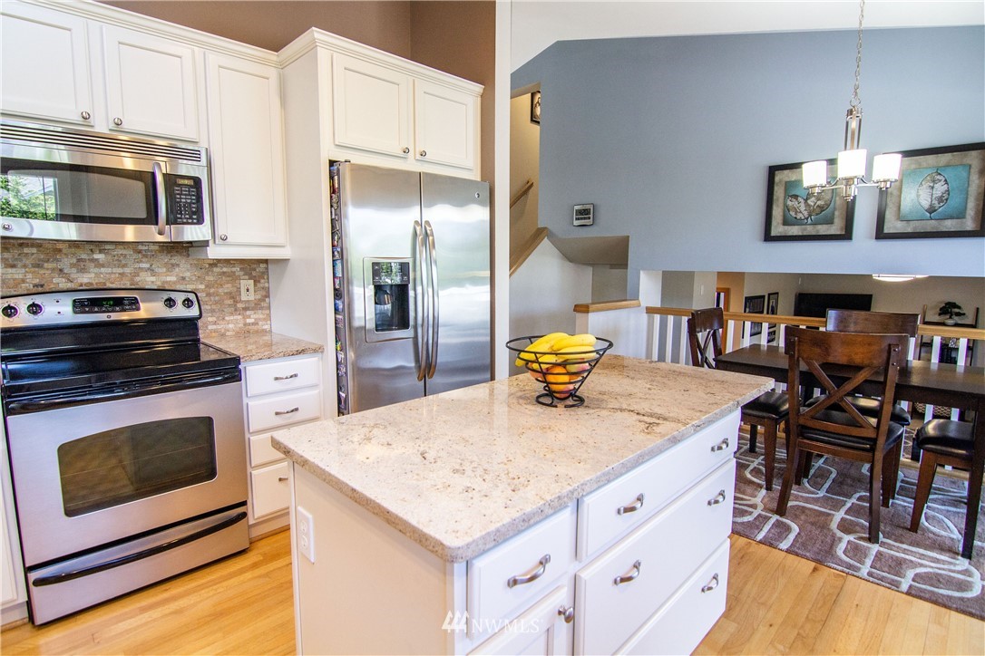 2311 Cedar Road Lake Stevens, WA 98258 - Photo 8 of 37 a kitchen with stainless steel appliances granite countertop a stove top oven a sink a dining table and chairs