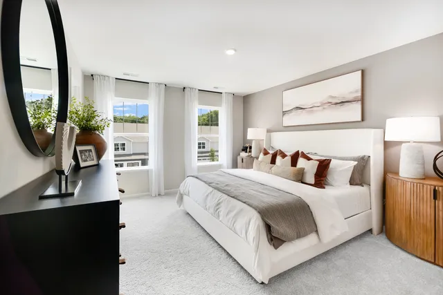 a bedroom with a bed a mirror and a large window